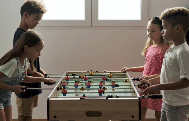 istock Group of multicultural children playing foosball 1270104228