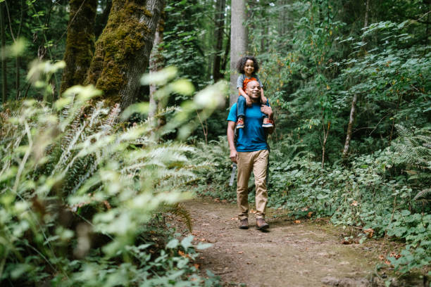 padre lleva a su hijo en caminata a través de sendero forestal en el noroeste del pacífico - northwest frontier fotografías e imágenes de stock