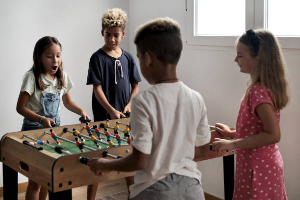 Group of multicultural children playing foosball