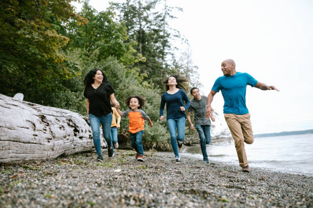 familie spielt zusammen am pacific northwest beach - african descent healthy lifestyle people water stock-fotos und bilder