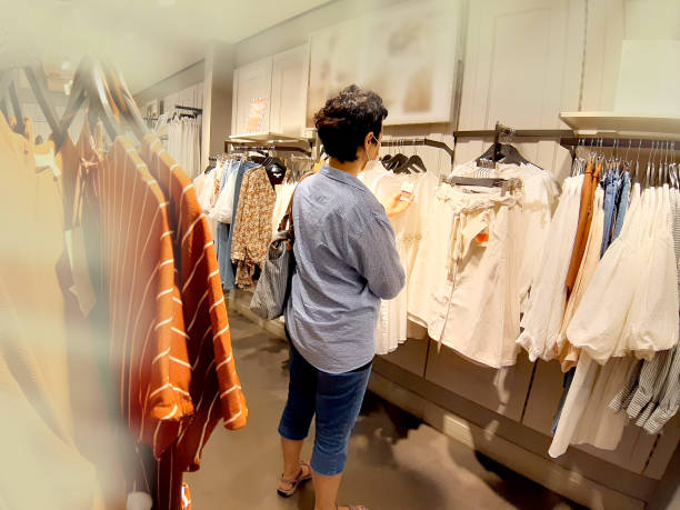 istock Woman Looking At Blouse While Out Shopping 1270107090