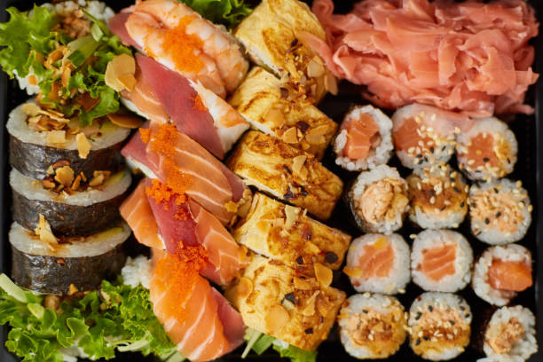 istock Close up of Various sushi set in black plastic delivery box. Top view 1270109435