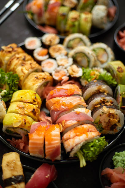 istock Assorted sushi set served on dark dark background. Top view of seafood, various maki rolls 1270109485