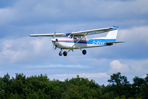 Ottawa, Canada. August 30, 2020. White and bliue Cessna 172M Skyhawk plane in flight on final approach into Rockcliffe airport in Ottawa