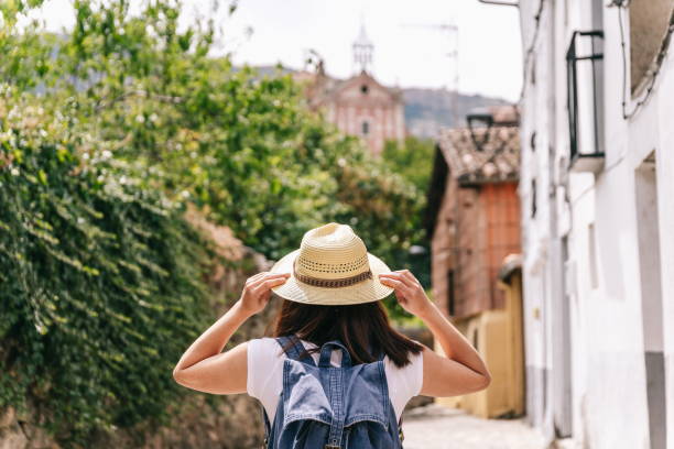 istock Independent woman sightseeing holding on to hat 1270112012