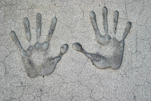 hand imprints in dry cement.