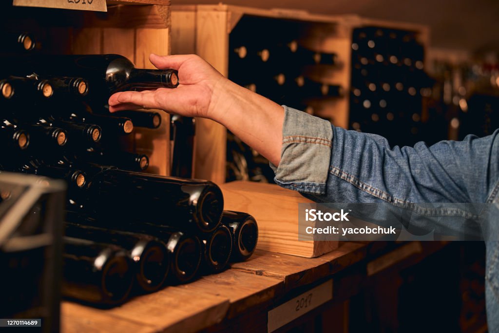 Reihen von Weinflaschen auf Holzregalen mit Jahren geschrieben - Lizenzfrei Weinkeller Stock-Foto
