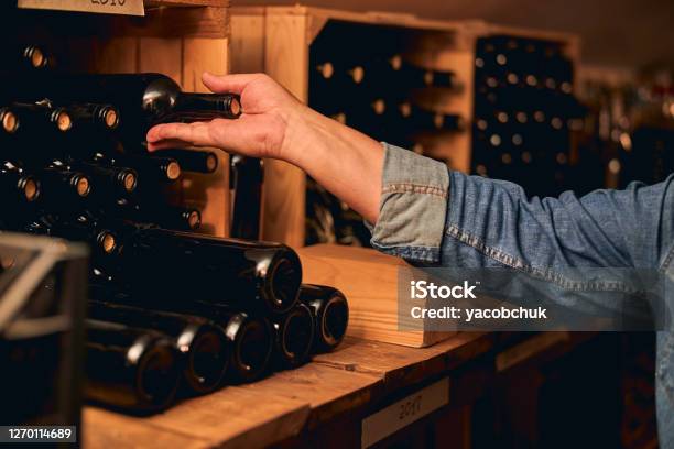 Reihen Von Weinflaschen Auf Holzregalen Mit Jahren Geschrieben Stockfoto und mehr Bilder von Weinkeller