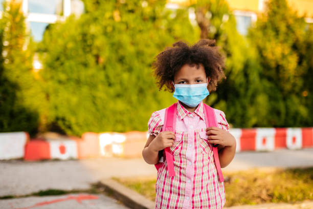istock Girl in schoolyard wearing face mask 1270115672