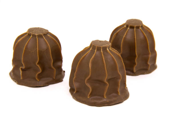 Close up color image depicting a box of gourmet chocolate truffles of different shapes and different varieties of chocolate. Selective focus with room for copy space.
