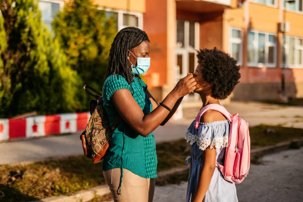 istock Mother putting a face mask to her daughter 1270116873