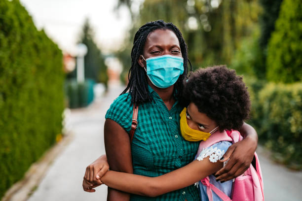 istock Mother embracing daughter in front of school 1270116968