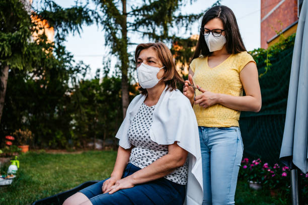 istock Volunteer doing haircut to mother during Coronavirus 1270117280