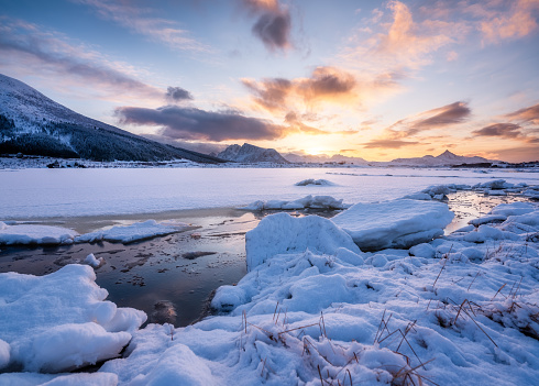 Lofoten islands, Norway. Mountains, ice with snow and clouds during sunset. Evening time. Winter landscape near the ocean. Norway - travel