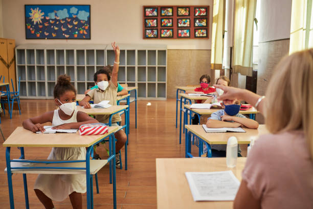 istock Diverse group of children studying in a classroom wearing protective face masks during coronavirus pandemic 1270122030