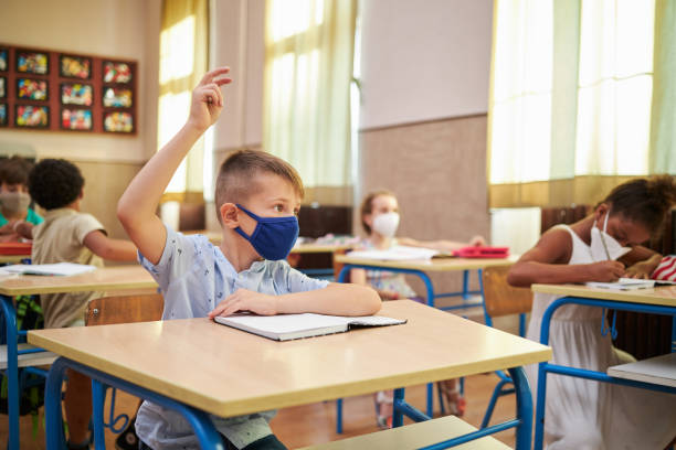 istock Young elementary student taking classes at school with a group of children during coronavirus pandemic 1270122116