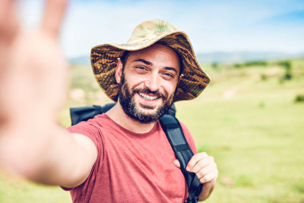 istock Hispanic Male With Hat Enjoying Hiking And Taking Selfie 1270122440