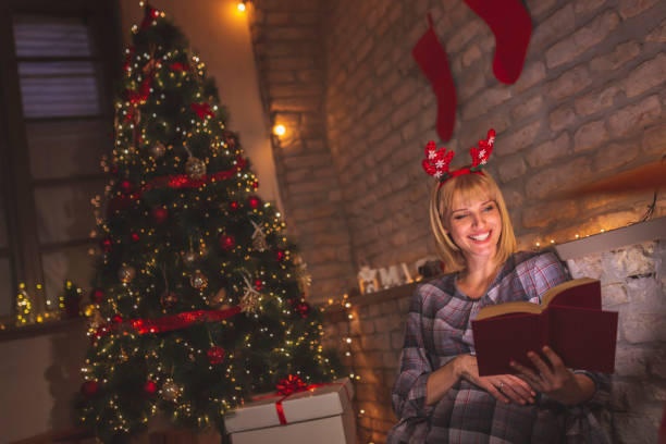 istock Woman reading a book on Christmas Eve 1270123544