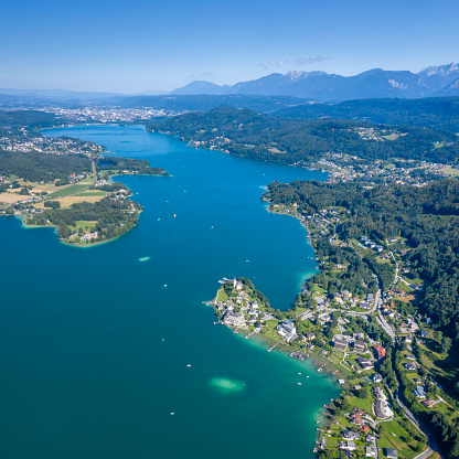Maria Wörth is a municipality in the district of Klagenfurt-Land in the Austrian state of Carinthia. The centre of the resort town is situated on a peninsula at the southern shore of the Wörthersee. In the east, the municipal area borders the Carinthian capital Klagenfurt. Aerial Panorama. Converted from RAW.