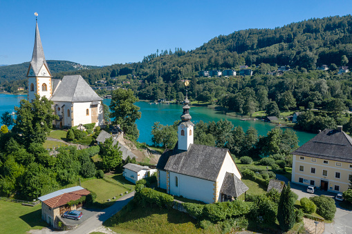 Maria Wörth is a municipality in the district of Klagenfurt-Land in the Austrian state of Carinthia. The centre of the resort town is situated on a peninsula at the southern shore of the Wörthersee. In the east, the municipal area borders the Carinthian capital Klagenfurt. Aerial Panorama. Converted from RAW.