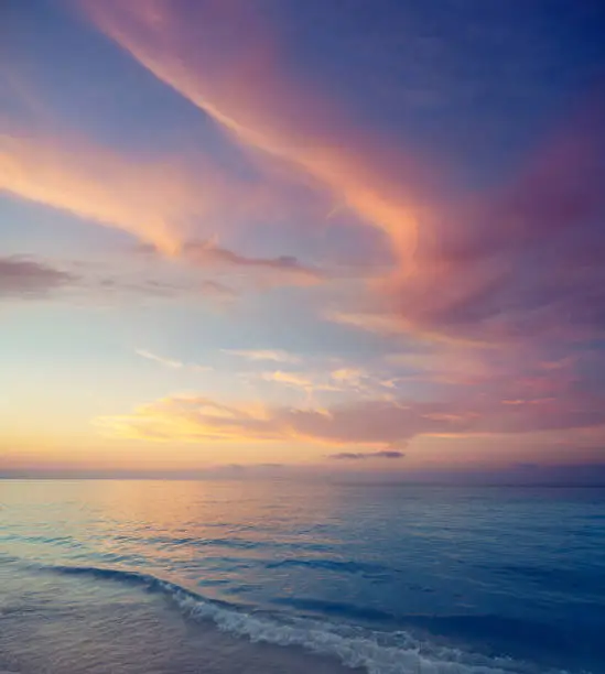 Sunset on the beach ocean sea with horizon on water soft colorful colors in pink orange and pastel blue