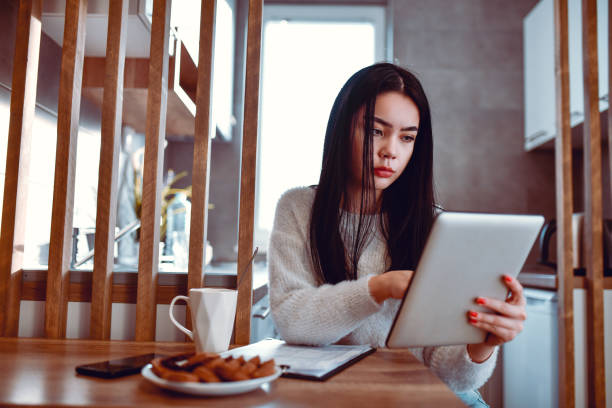 istock Beautiful Asian Female Working While Drinking Coffee And Eating Cookies 1270124779