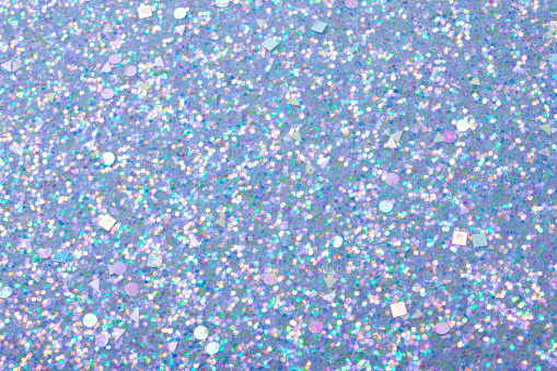 Holographic bright light blue glitter real texture background.