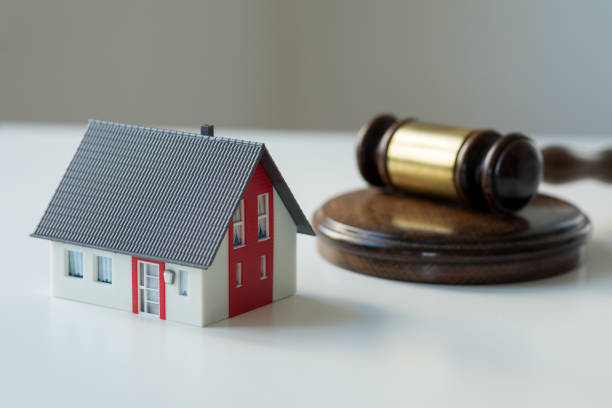 A miniature house beside a gavel