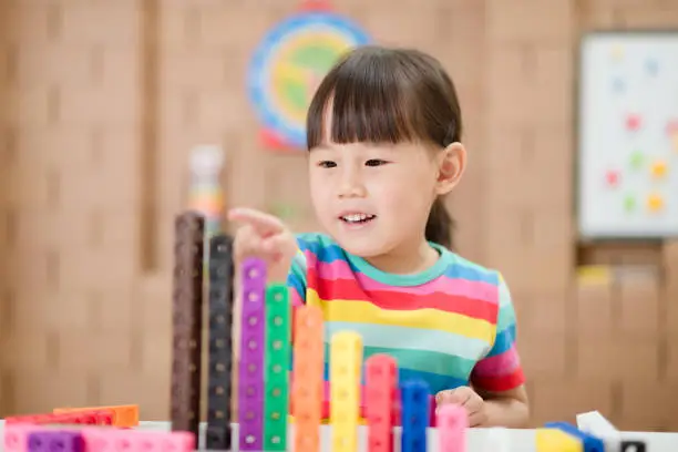 young girl play number sticks for home schooling