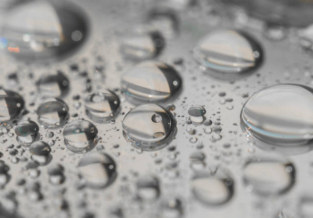 Macro photography of water drops on a mirror reflective surface. Concept of a couple in love and relationship Macro photography of water drops on a mirror reflective surface. Concept of a couple in love and relationship water thinking bubble drop stock pictures, royalty-free photos & images