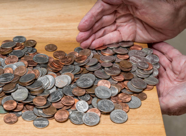 istock Hands scooping up loose USA change with mixed coins on wooden table 1270130375