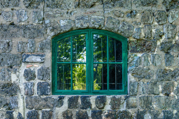 Old green vaulted window on a cinder block wall from an old industry building in Sweden