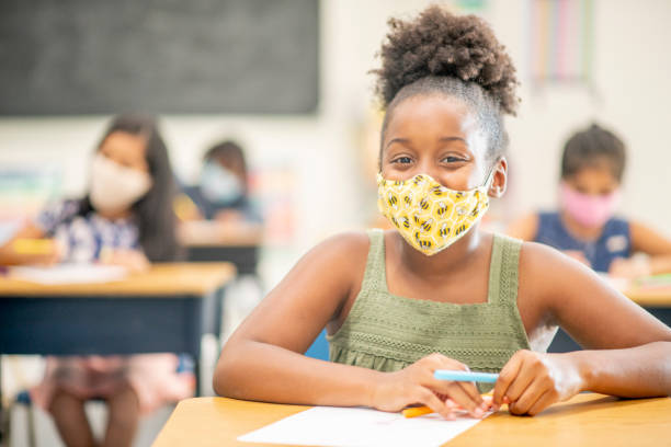 istock Young female student wearing a face mask in the classroom 1270134347