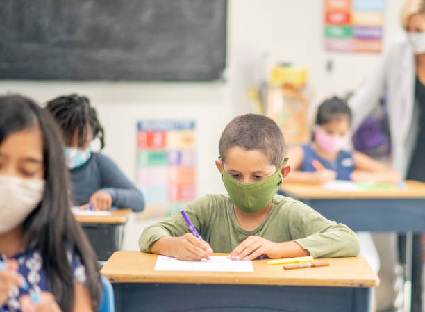 istock Elementary school children wearing face masks in class 1270134354