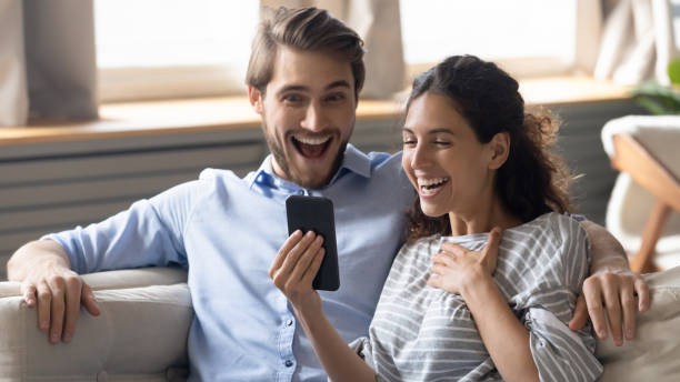 istock Emotional young overjoyed couple looking at smartphone screen. 1270135880