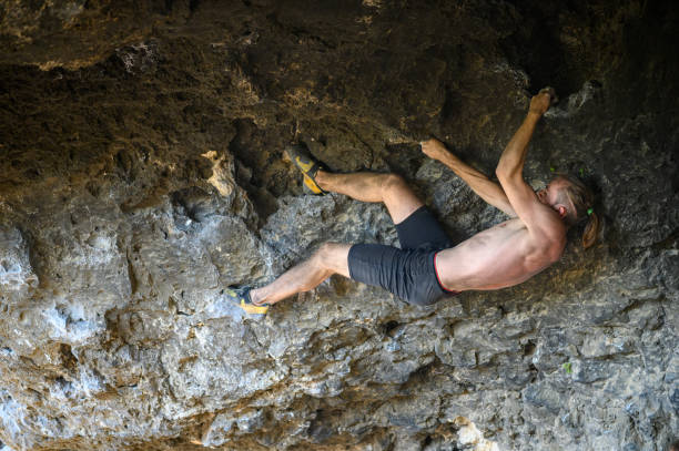istock Young male climber bouldering a rock wall in a cave 1270137389