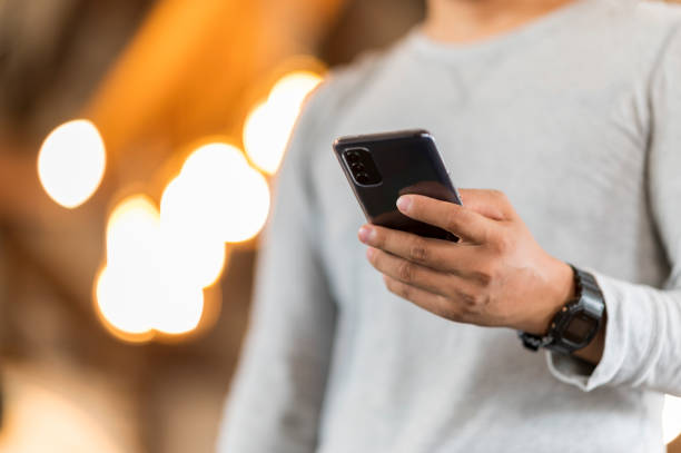 istock Close up of a man using mobile smart phone In cafe bokeh background 1270139814