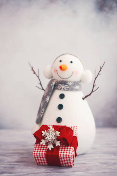 Christmas decorative snowman on white rustic wooden background.
