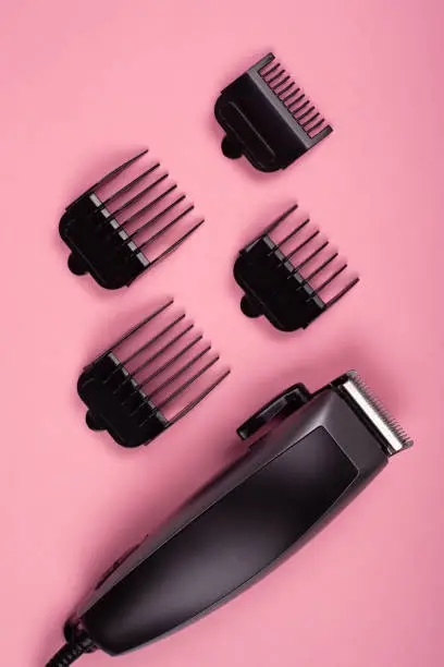 hair clipper trimmer on pink background, hairdresser accessory.