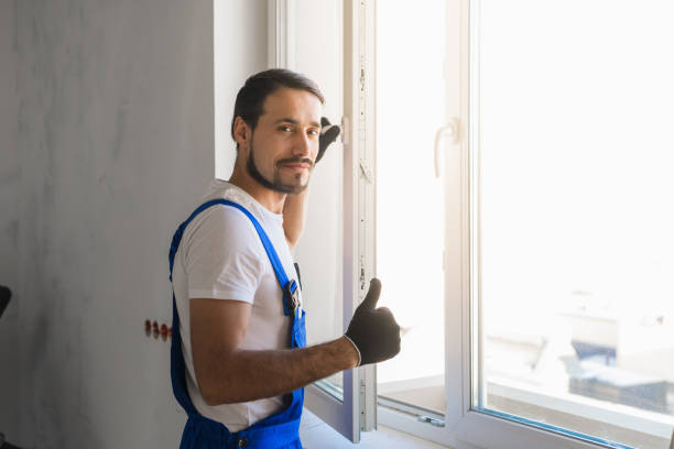 Craftsman installs the window and looks at the camera stock photo