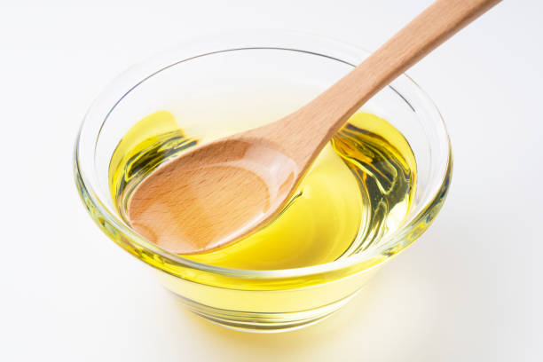 istock Vegetable oil and wooden spoon on a white background 1270154969