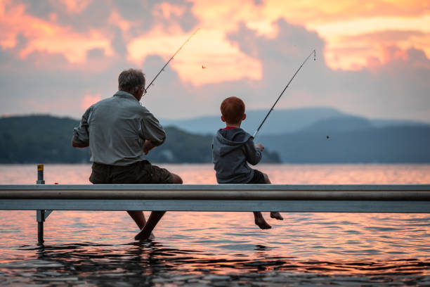 pêche de grand-père et de petit-fils en été - fishing lake grandfather grandson photos et images de collection