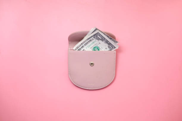 Top view of us dollar in a wallet on pink background.