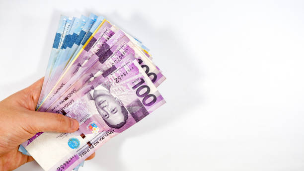 Paying and receiving of Philippine Peso bills on white background Philippine currency bill 1000, 500 and 100 denominations philippines currency stock pictures, royalty-free photos & images