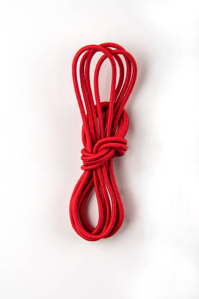lacets élastiques de chaussure rouge dans un échevelage sur un fond blanc. gros plan. - knitting vertical striped textile photos et images de collection