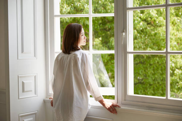 young asian woman looking through window