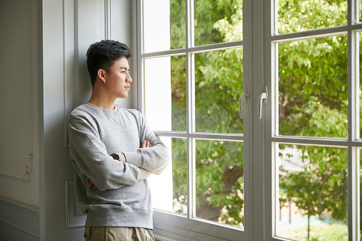 joven asiático en cuarentena quedándose en casa photo