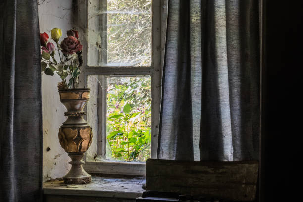 istock Vase with flowers made of plastic on a window with a curtain 1270183623