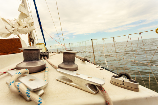 Yacht capstan with rope on sailing boat during cruise, marine objects concept.