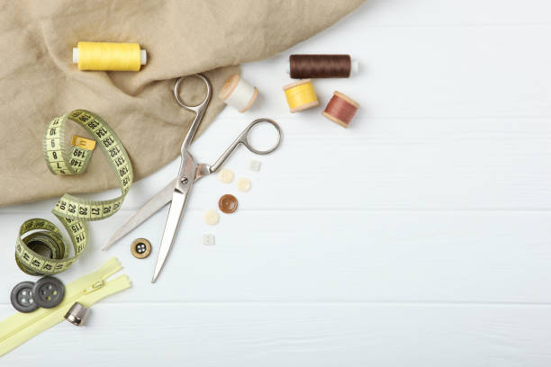 istock different sewing accessories on the table. Threads, needles, pins, fabric and sewing scissors close up 1270186472